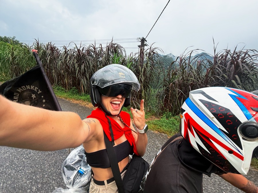 Gio de capacete, de garupa na moto durante o loop